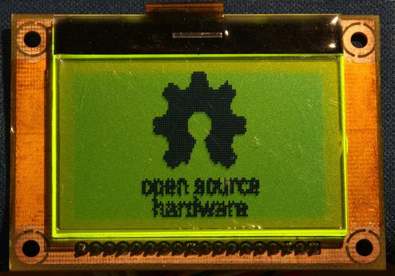A picture of a graphical LCD showing the Open Source Hardware logo
