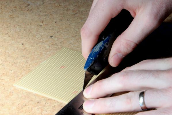 Use a steel ruler, a good knife and a cutting mat.  Be careful cutting stripboard, it's quite hard so easy for the knife to slip.